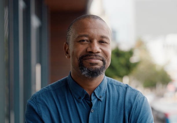 Business, portrait and black man in city outdoor for career or job of businessman. Face, confidence and professional entrepreneur in urban town with employee and African salesman working in Kenya